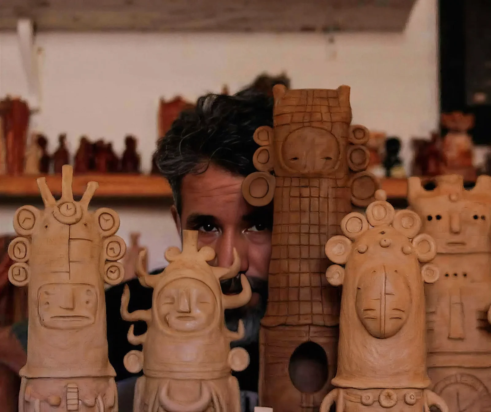 Giovanni Acevedo (Nuka) entre sus esculturas de cerámica
